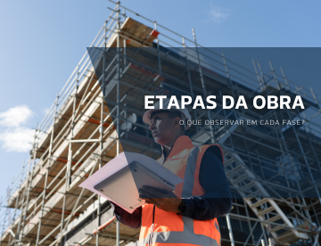Profissional da construção civil usando colete e capacete de segurança enquanto analisa documentos em frente a uma obra em andamento com andaimes ao fundo.
